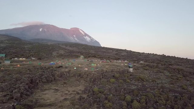 Establishing shot, showing the Shira Camp from above, Kibo Peak in the back during sunset.