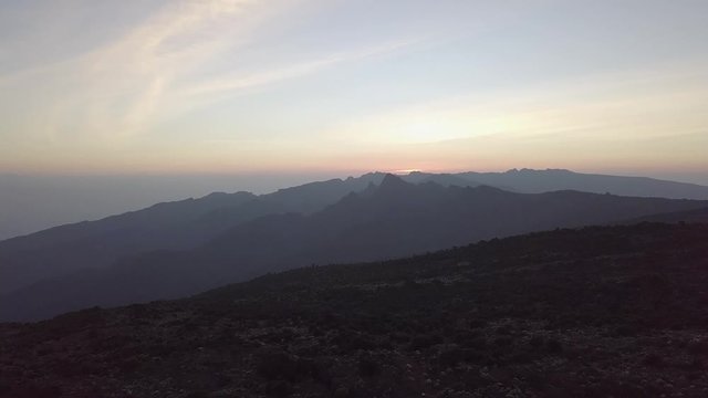 Aerial dolly forwards, flying near the Kilimanjaro at the Shira Peak during sunset.