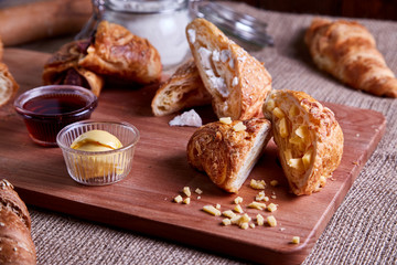 Freshly baked croissants and pate on wooden cutting board