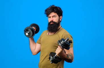 Fototapeta na wymiar Fitness. Strong man training with dumbbells. Bearded man exercise with dumbbells. Handsome athlete man with dumbbells. Sportsman with dumbbells training. Sportsman making weightlifting. Lose weight.