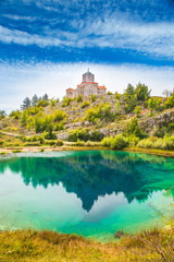 Fototapeta na wymiar Croatia, Cetina river source water hole and small Orthodox church in Dalmatian Zagora karst landscape