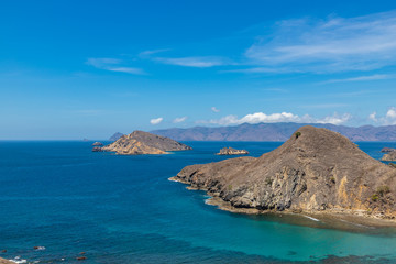 Tropical sea and small islands around Komodo National Park with hills, blue sea water and blue sky. Indonesia