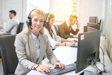 Young blonde female receptionist with headset in office