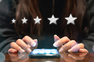 Woman filling out 5 star silver customer service feedback survey by email on smartphone device...