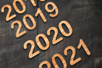 2020 running year numbers by wood letters on wood background.