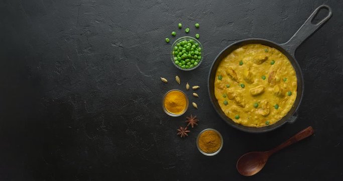 Cinemagraph loop. Cooking tasty chicken curry in pan with spices. Flat lay, top view with copy space
