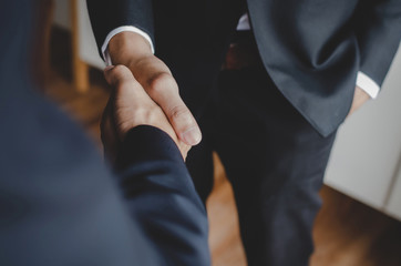 Partnership. two business people standing and shaking hand after business signing contract in meeting room at office, job interview, success, negotiation, partnership, teamwork, financial concept