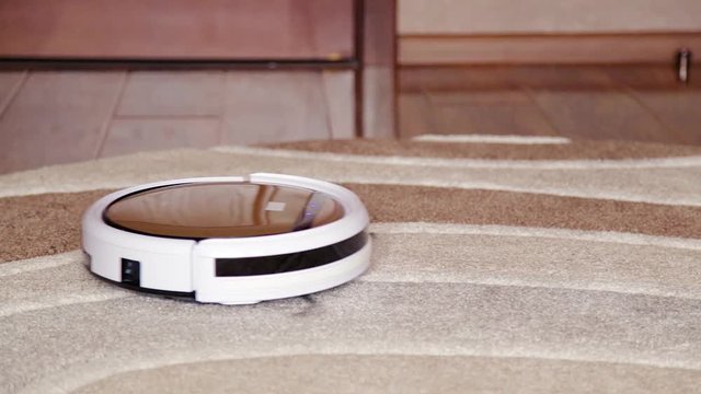 Robot vacuum cleaner cleans the floor from dust. Smart house.