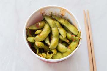 Healthy Take Away Asian Food Spicy Sambal Edamame with Chopsticks / Spiced Style with Red Hot Chili Sauce in Plastic Box Package / Container.