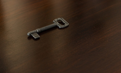 soft focus old iron key lay on wooden perspective surface brown background 
