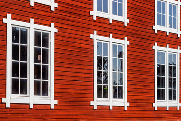 Fototapeta na wymiar Beautiful old red wooden facade with windows