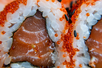 Macro of sushi chopsticks with salmon.