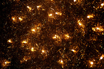 Fototapeta na wymiar Part of Christmas decorative yellow and white flashing lights, close up. Detail of New Year and Christmas decorations, string rice lights bulbs. Ornaments to christmas celebration, holiday scene.