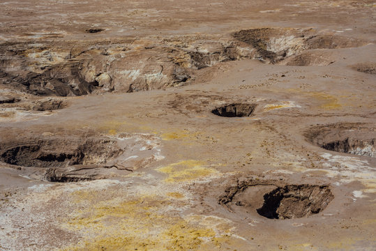 Hot geysers with mud and sulfur crystals in the volcano crater