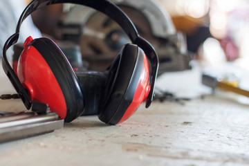 Ear muffs, safety devices prevent loud noises on wooden tables.