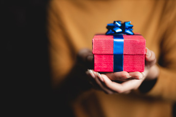 Happy women hands holding Christmas gift box.