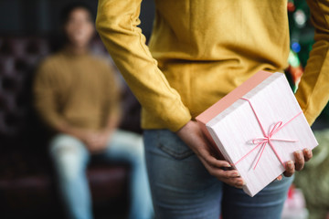 Women gaving Christmas gift box to man.