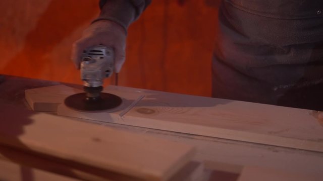 A man polishes wooden furniture before painting it