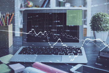 Financial chart drawing and table with computer on background. Multi exposure. Concept of international markets.