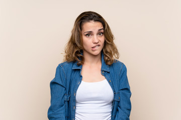 Obraz premium Young blonde woman over isolated background having doubts and with confuse face expression