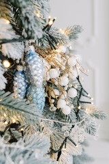 Decorative silver toy on tree with sparkling lights. Selective focus. Festive background.