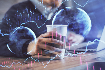 Forex graph with businessman working on computer in office on background. Concept of hardworking. Closeup. Multi exposure.