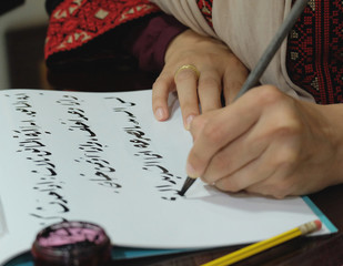 freelancer artist working on the arabic word callgraphy project in creative studio. Qatar, Doha