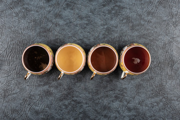 Hot drinks tea, coffee, chocolate in cups on a gray stone table.