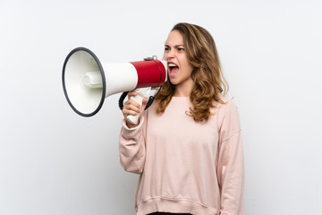 Young blonde woman shouting through a megaphone