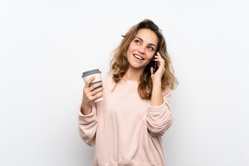 Young blonde woman holding coffee to take away and a mobile
