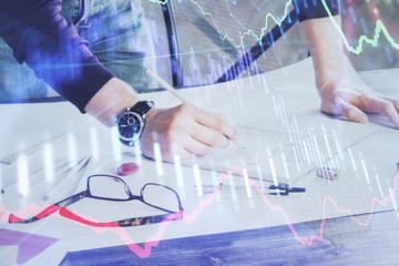 Multi exposure of man standing and planing investment with stock market forex chart.