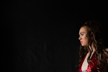 Naklejka premium portrait of a sexy girl with long hair in a short dress with an open back on a black background