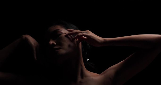 Fashion art portrait of sexy woman posing in black background. 4K UHD Slow motion video