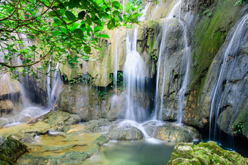Fototapeta na wymiar Mature trees and milky falls at Thac Voi waterfall, Thanh Hoa, Vietnam