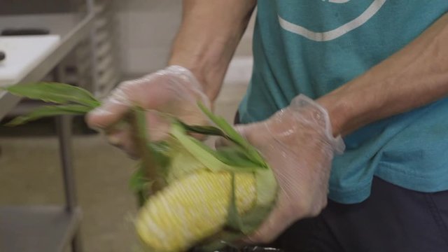 Paella event catering with a healthy choice raw corn huck husking corn prepare prep for food vender event catering