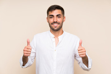 Handsome man with beard over isolated background giving a thumbs up gesture