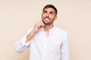 Handsome man with beard over isolated background thinking an idea