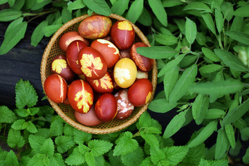 Painted Easter eggs in vintage basket, top view. Happy Easter