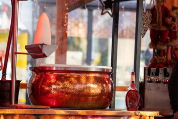 Heiße Feuerzangenbowle mit Zuckerhut und Kufperkessel dampft auf einem Weihnachtsmarkt und lädt...