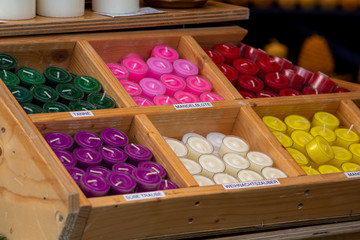 Bunte Duftkerzen und farbenfrohe Kerzen auf einem Marktstand eines Weihnachtsmarkt oder...