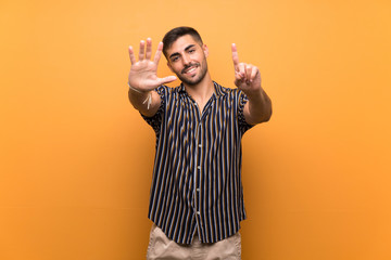 Handsome man with beard over isolated background counting six with fingers