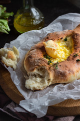 Khachapuri, traditional Georgian cuisine. Adjarian open bread pie with cheese and egg yolk. Caucasian kitchen. 