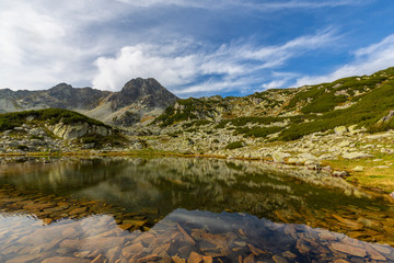 Fototapeta na wymiar Marvelous glacier lake in the Romanian Alps, in summer, and dramatic storm clouds