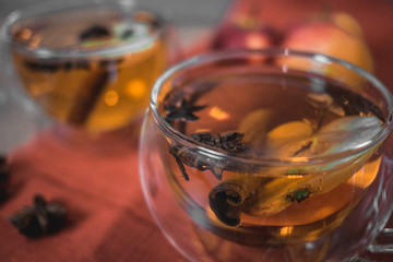 Apple Cider Drink, Juice, Punch, Tea with Spices, Cinnamon sticks, star anise and fresh Apples on a wooden background. Hot drink for Autumn and Winter evenings. Close up. Seasonal mulled drink.