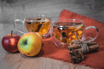 Apple Cider Drink, Juice, Punch, Tea with Spices, Cinnamon sticks, star anise and fresh Apples on a wooden background. Hot drink for Autumn and Winter evenings. Close up. Seasonal mulled drink.