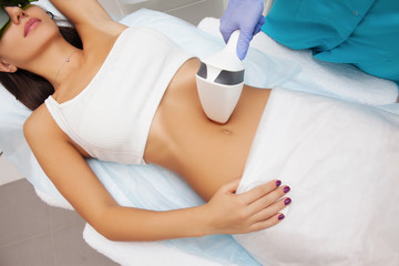 Laser epilation and cosmetology in beauty salon. Hair removal procedure. Laser epilation, cosmetology, spa, and hair removal concept. Beautiful woman getting hair removing on belly