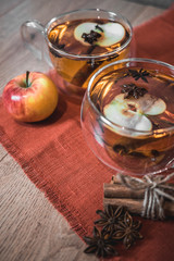 Apple Cider Drink, Juice, Punch, Tea with Spices, Cinnamon sticks, star anise and fresh Apples on a wooden background. Hot drink for Autumn and Winter evenings. Close up. Seasonal mulled drink.