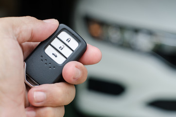Car smart key is an electronic access and authorization system, Hand holding smart key of car.