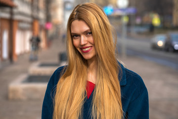 Fototapeta premium Young beautiful blonde woman in a blue coat