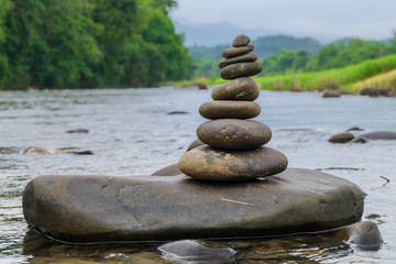 Stacked stones on the river with nature background